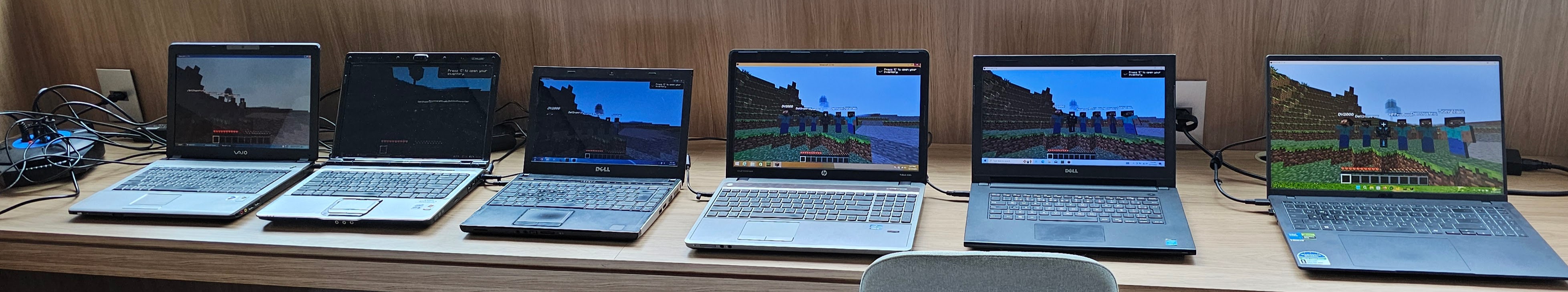 Six laptops in a row, each running Minecraft on a different Windows version from XP through 11